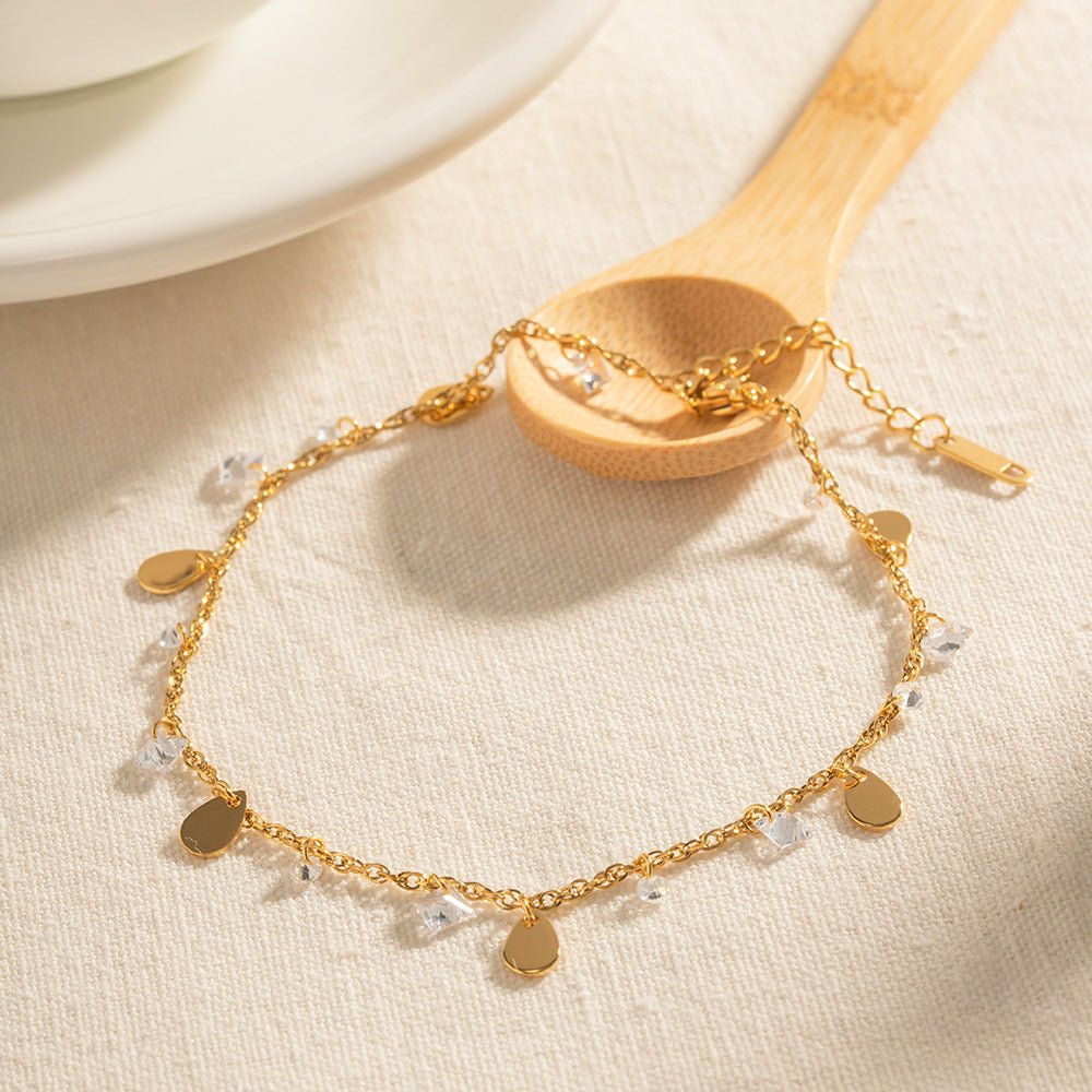 Bracelet de cheville or en acier inoxydable à double rang avec petits cristaux et pampilles rondes fines.