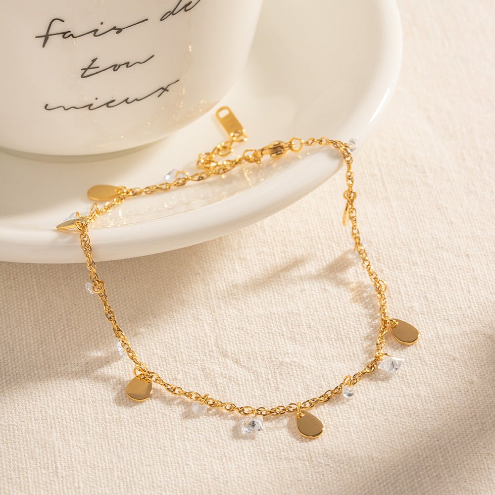 Bracelet de cheville doré double rang avec pampilles et cristaux brillants délicats.