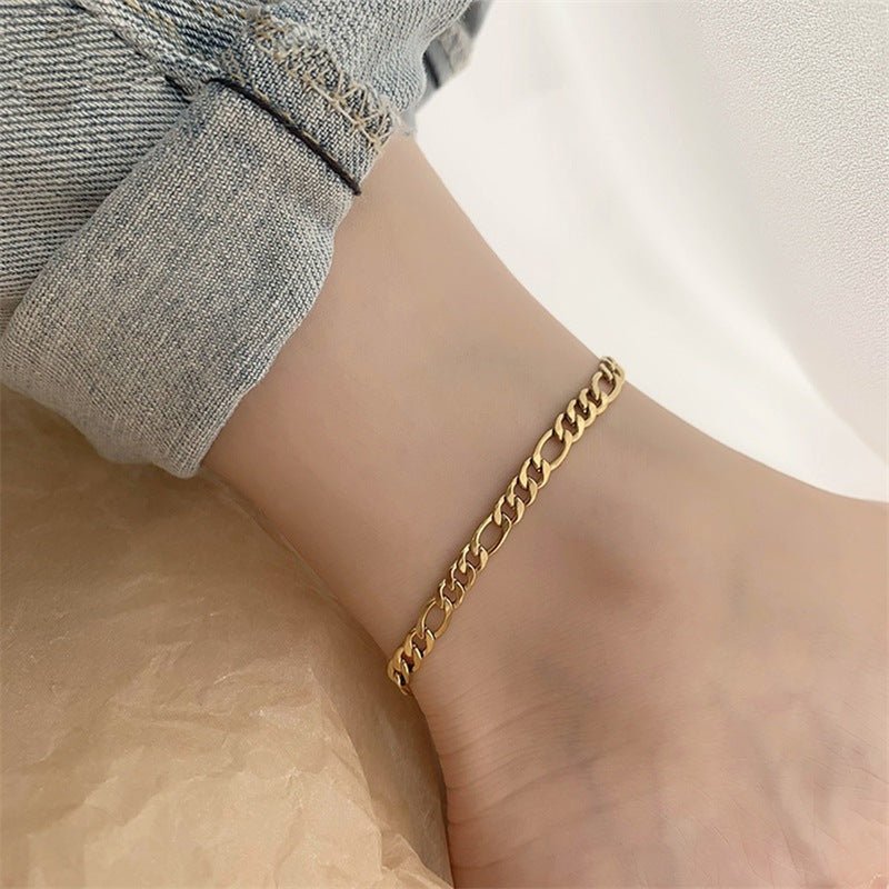 Bracelet de cheville en acier inoxydable doré avec maille figaro fine et élégante.