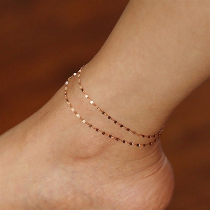 Bracelet de cheville or rosé en acier inoxydable à maille grain de café double tour délicate.