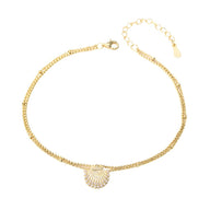 Bracelet de cheville doré en argent sterling avec pendentif coquillage marine délicat.