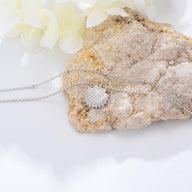 Bracelet de cheville en argent sterling avec pendentif coquillage fin posé sur pierre claire.