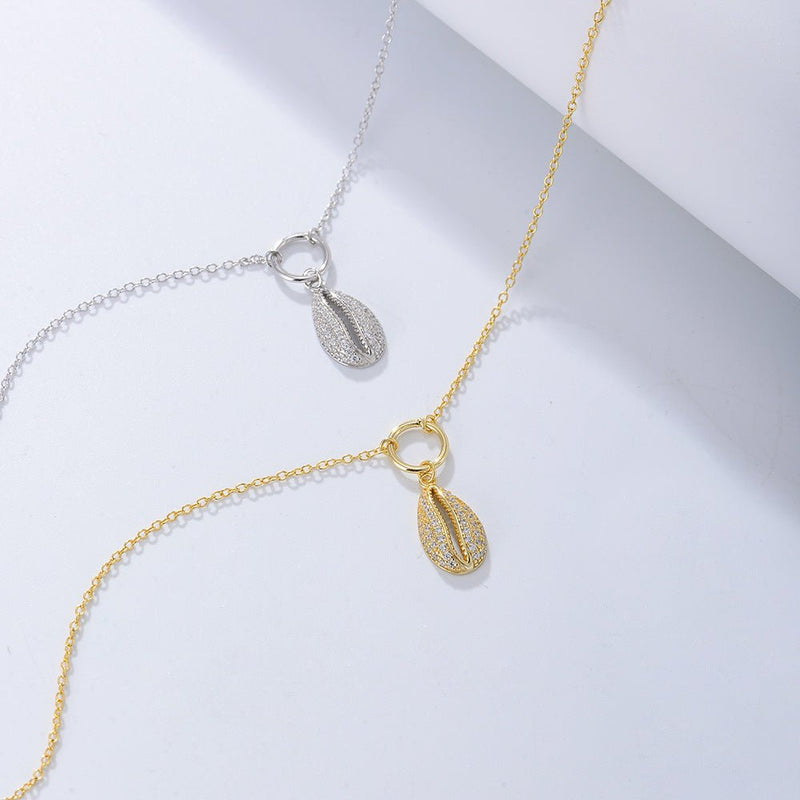 Bracelet de cheville fin en argent sterling et en or avec pendentif coquillage de mer détaillé.