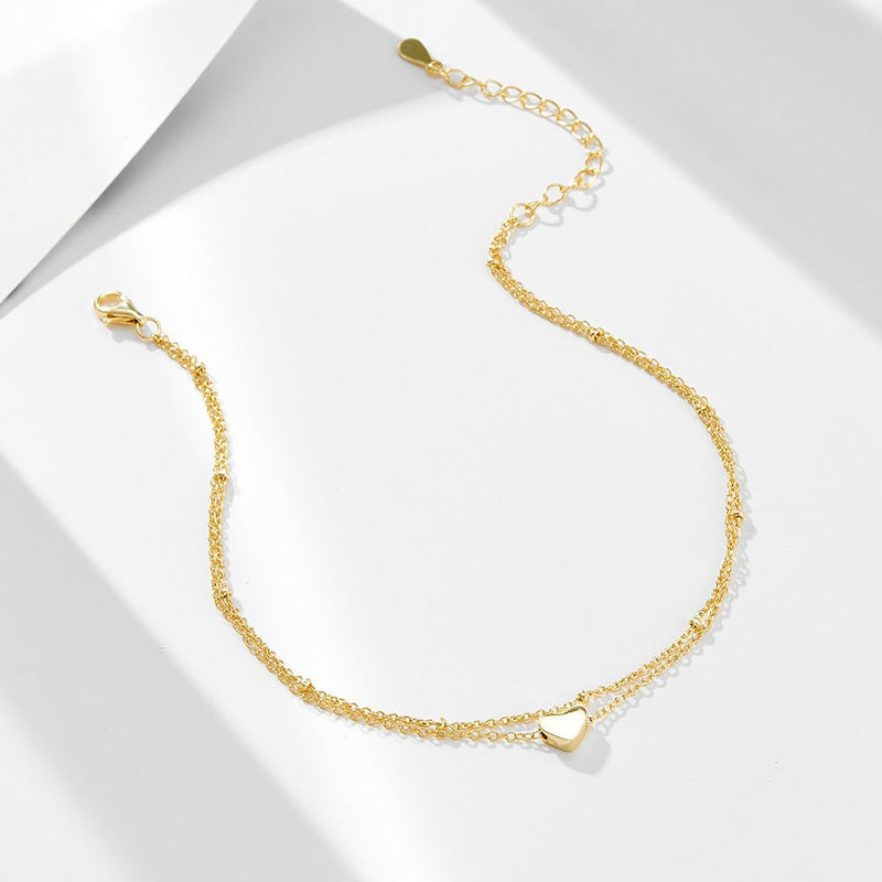Bracelet de cheville doré en argent sterling avec pendentif cœur lisse et chaîne fine.