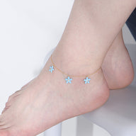 Bracelet de cheville en argent sterling avec fleurs bleues suspendues, design délicat et féminin.