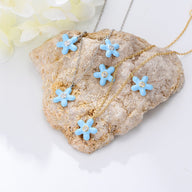 Bracelet de cheville en argent avec fleurs bleues émaillées et centre doré délicat.