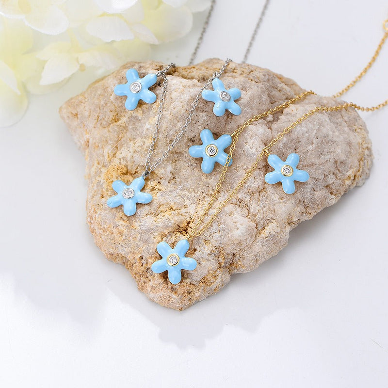Bracelet de cheville en argent avec fleurs bleues émaillées et centre doré délicat.