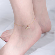 Bracelet de cheville doré fin avec pendentif queue de sirène et petits cœurs délicats.