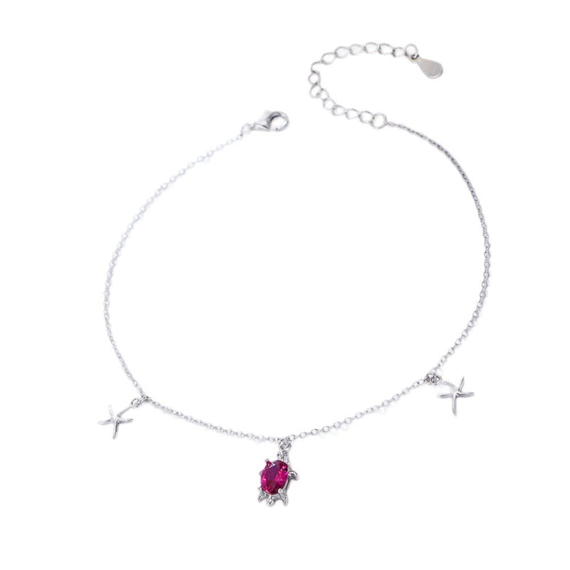 Bracelet de cheville en argent sterling avec pendentifs tortue et étoiles de mer, orné d'une pierre rouge éclatante.