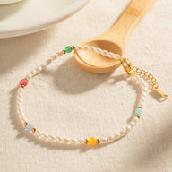 Bracelet de cheville en perles d'eau douce blanches avec perles colorées et fermoir en acier doré.