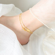 Bracelet de cheville en titane doré, motif cœur et inscription love, style délicat pour femme.