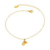 Bracelet de cheville fin en titane doré avec pendentifs cloches délicats.