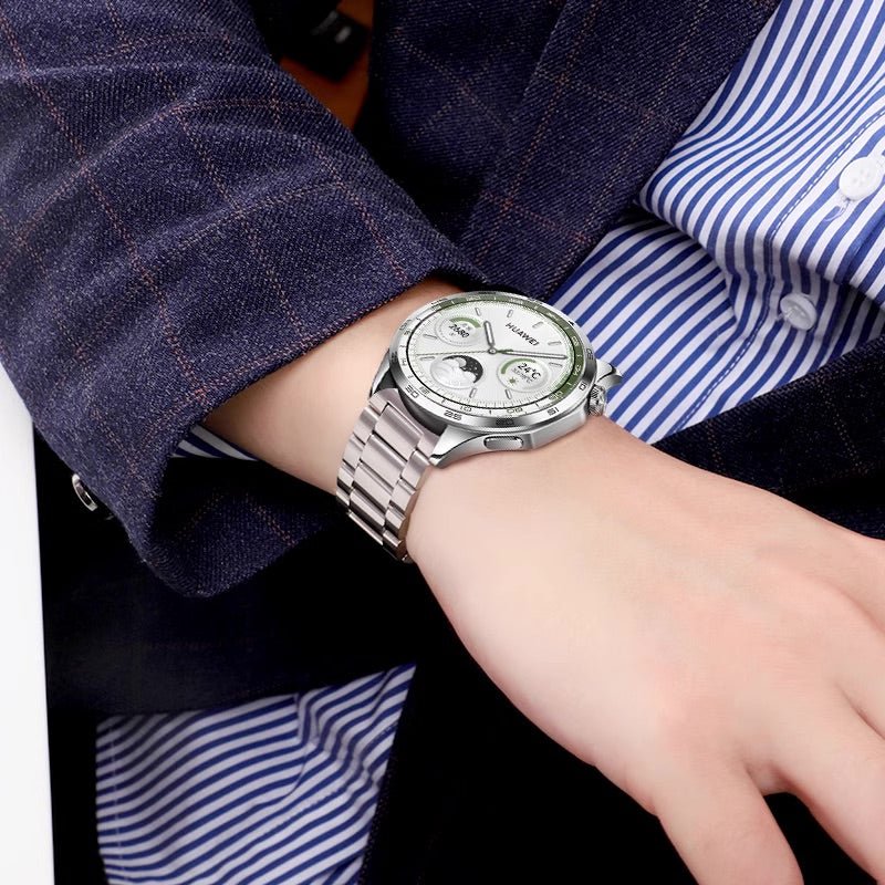 Bracelet de montre connecté en acier inoxydable argent à maillons, porté avec une montre à cadran blanc.