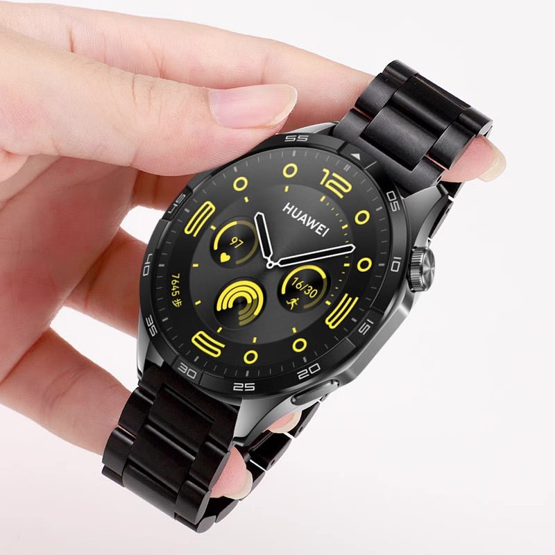 Bracelet de montre connecté noir à maillons en acier inoxydable pour Huawei Watch, cadran rond noir avec détails jaunes.