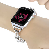 Bracelet chaîne argentée avec pendentif cœur pour Apple Watch modèle Donatia sur poignet féminin.