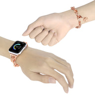 Bracelet chaîne doré rose avec pendentif cœur pour Apple Watch porté au poignet.