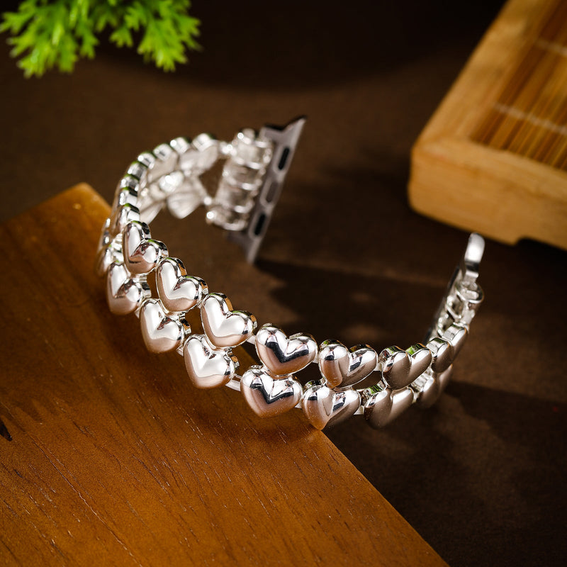Bracelet pour Apple Watch en métal argenté orné de petits cœurs ajourés élégants.