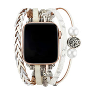 Bracelet Apple Watch blanc avec multiple brides en cuir et breloques, arbre de vie et perles décoratives.