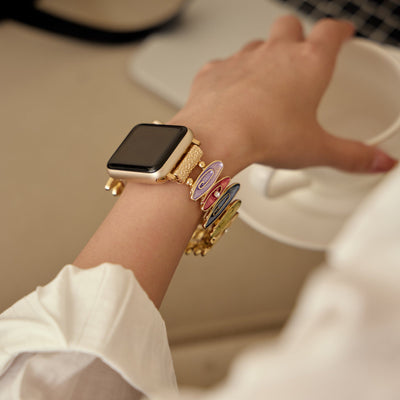 Bracelet coloré pour Apple Watch modèle Marisol, ajustable, porté au poignet féminin avec montre dorée.