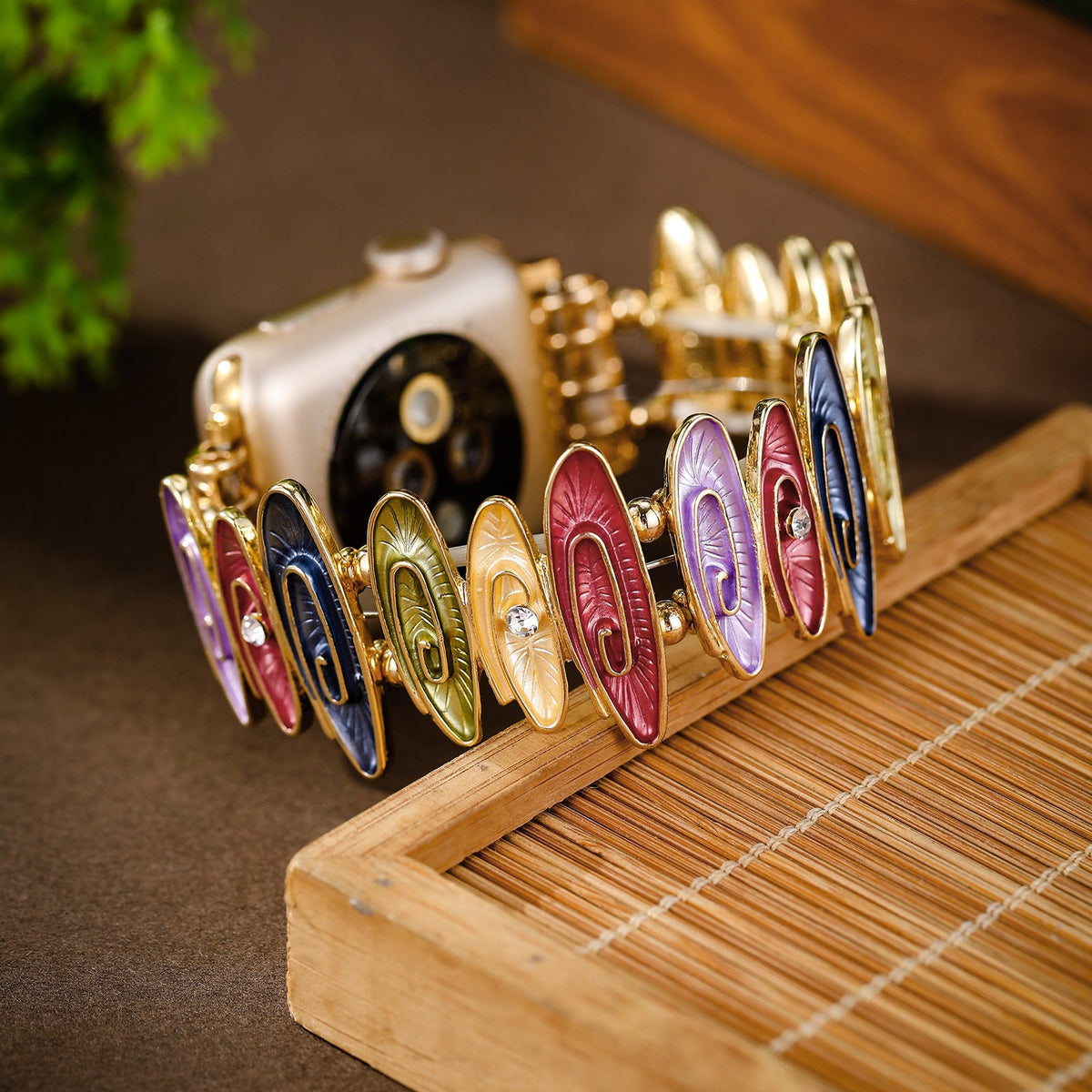 Bracelet Apple Watch femme Marisol multicolore avec maillons ovales décoratifs en métal doré.