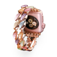 Bracelet Apple Watch femme aux pétales scintillants multicolores sur métal rose doré.