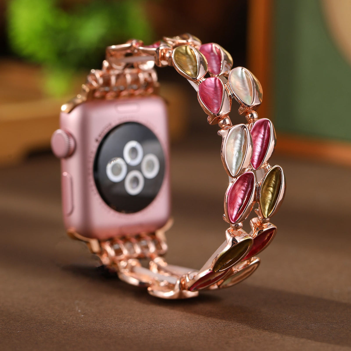 Bracelet Apple Watch femme modèle Raquel pétales métalliques rose et or scintillants.