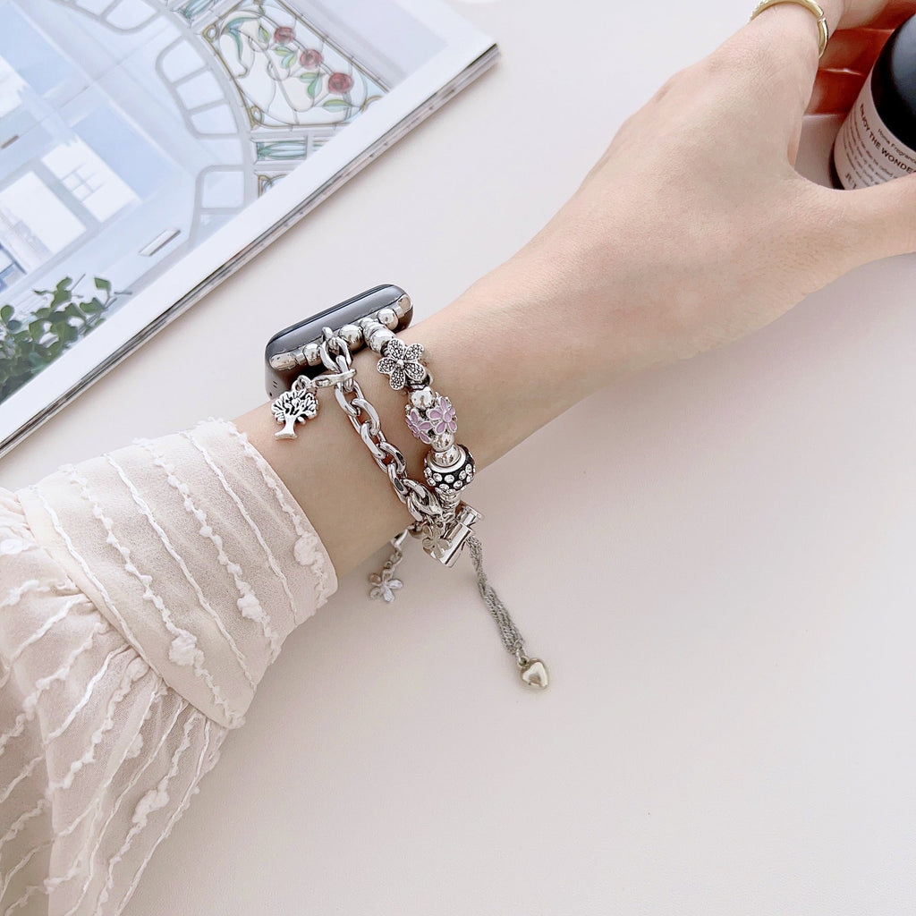 Bracelet double-rangs en cuir rose avec multiples charms argentés pour Apple Watch.