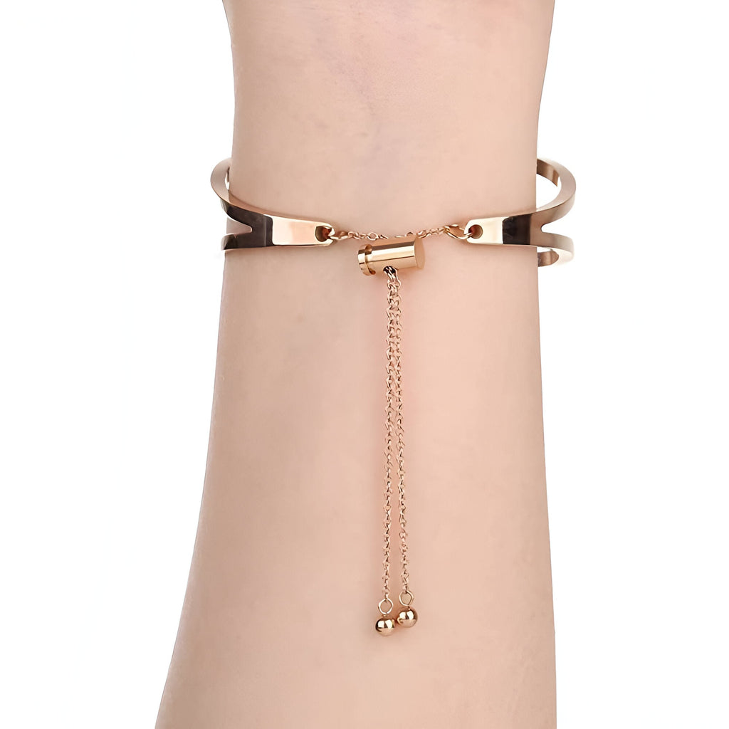 Bracelet pour femme en acier inoxydable or rosé, style manchette avec chaîne réglable et finition lisse.
