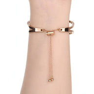 Bracelet pour femme en acier inoxydable or rosé, style manchette avec chaîne réglable et finition lisse.