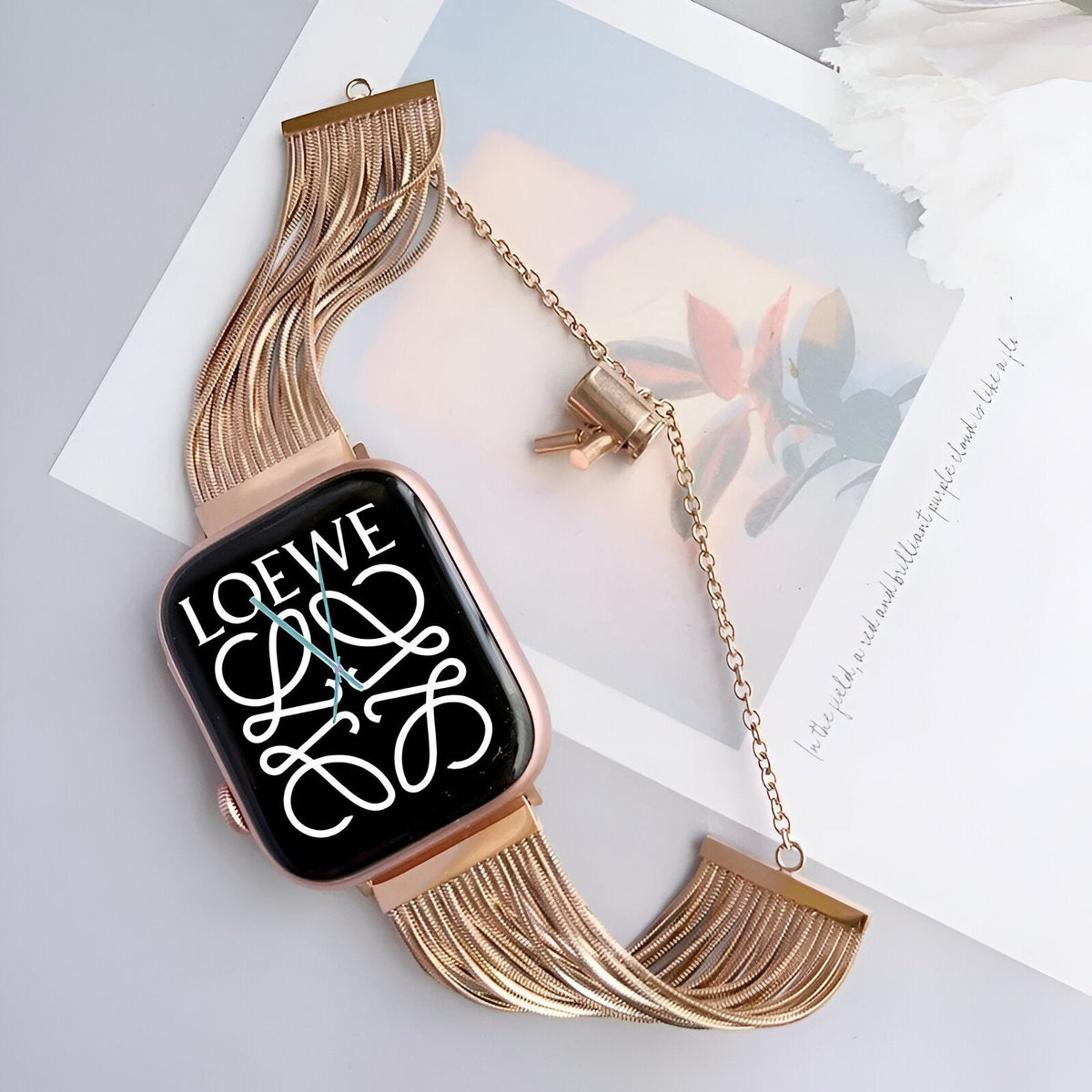 Bracelet Apple Watch en acier inoxydable or rosé avec mailles fines et fermeture chaîne ajustable.