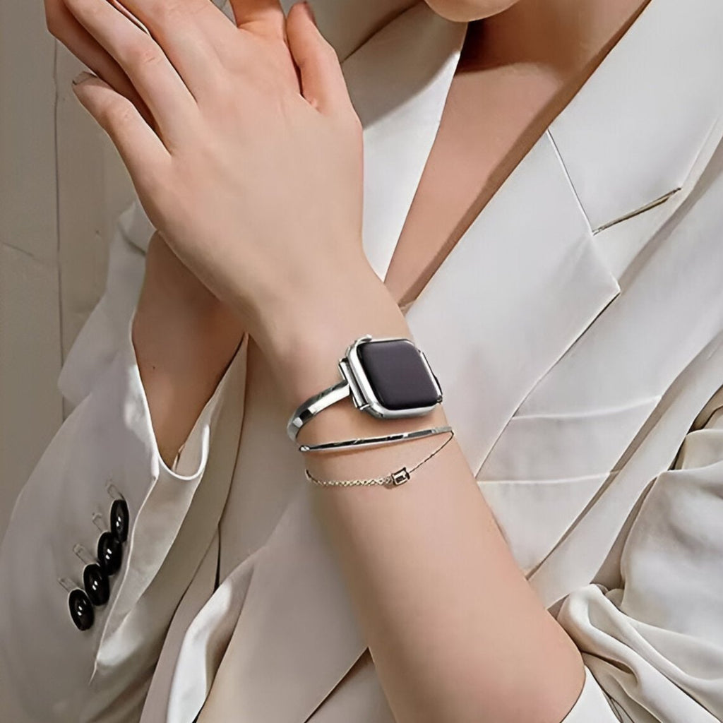 Bracelet Apple Watch argent en acier inoxydable style double tour porté avec veste blanche.