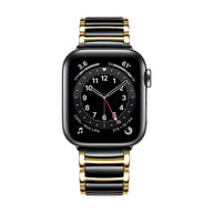 Bracelet Apple Watch en acier inoxydable noir et or avec maillons larges et finition brillante.