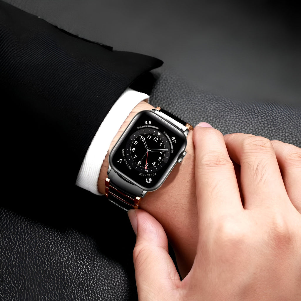 Bracelet Apple Watch en acier inoxydable noir et argent porté sur poignet masculin avec costume noir.