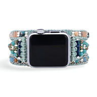 Bracelet pour Apple Watch bleu en cristal avec détails verts et dorés, style Nexa pour femme.