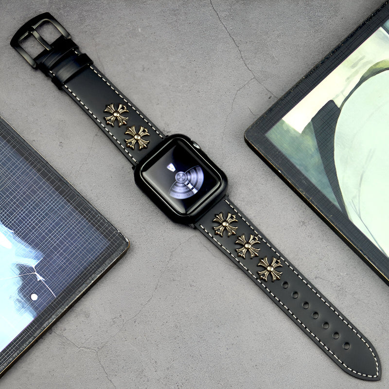 Bracelet Apple Watch en cuir noir avec rivets dorés décoratifs et coutures contrastantes blanches.