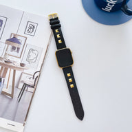 Bracelet Apple Watch en cuir noir avec rivets carrés dorés, boucle dorée élégante.