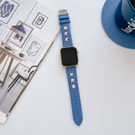 Bracelet Apple Watch en cuir bleu roi avec rivets carrés métalliques et boucle argentée.