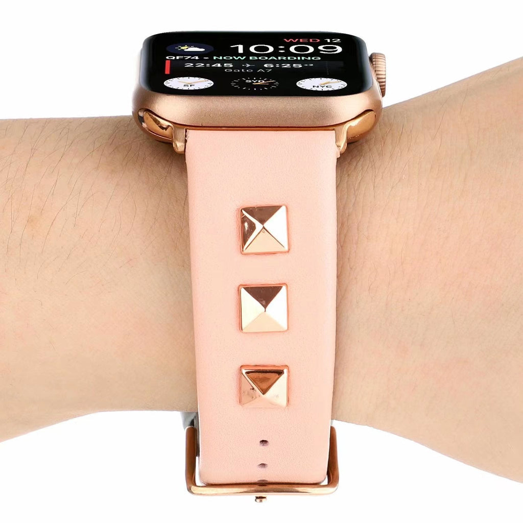 Bracelet en cuir rose pâle pour Apple Watch avec trois rivets carrés dorés.