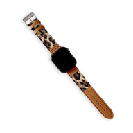 Bracelet Apple Watch en cuir marron et denim motif léopard avec boucle argentée.