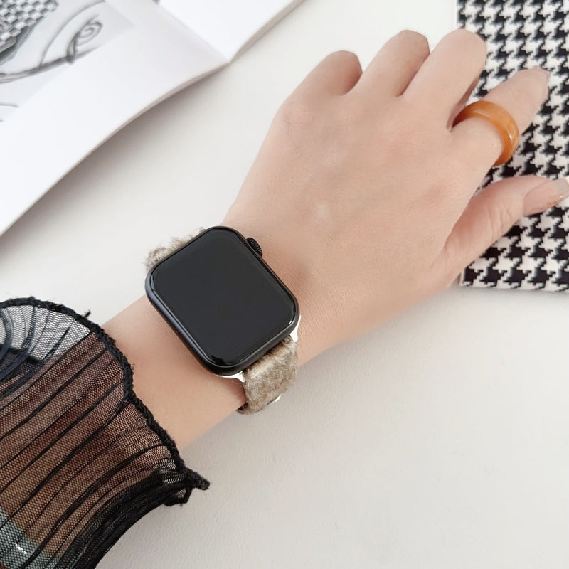 Bracelet Apple Watch en cuir beige avec intérieur en laine douce porté au poignet féminin.