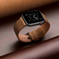 Bracelet Apple Watch en cuir cognac, boucle noire, style classique et élégant.