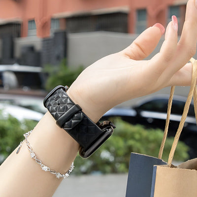 Bracelet Apple Watch en cuir noir matelassé avec boucle noire, style mixte, porté au poignet.