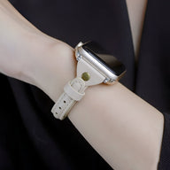 Bracelet Apple Watch en cuir blanc avec boucle métallique dorée et surpiqûres visibles.