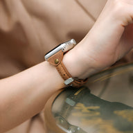 Bracelet Apple Watch en cuir marron clair avec boucle argentée et surpiqûres visibles.