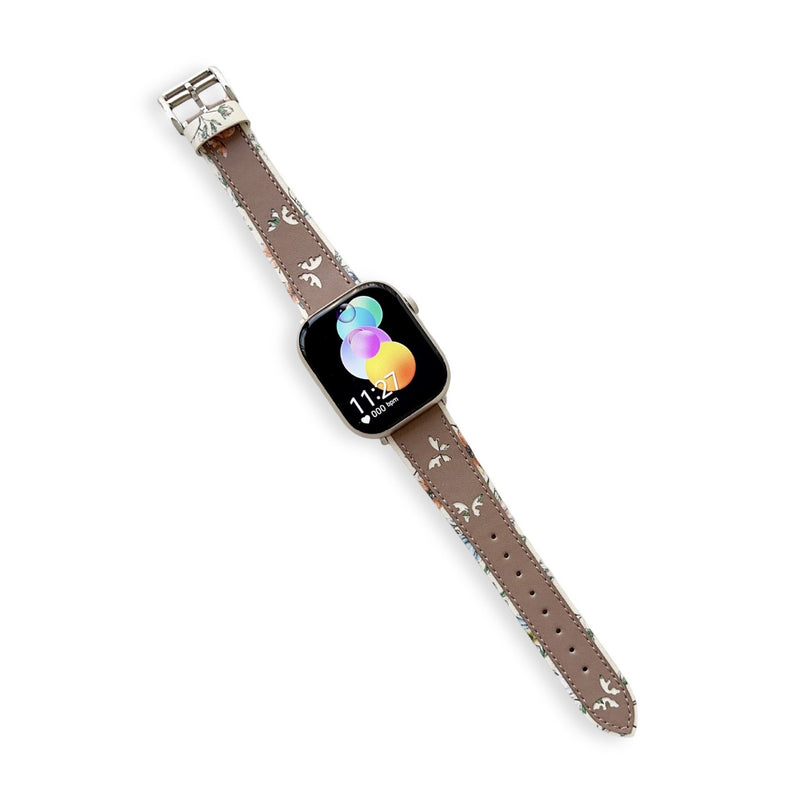 Bracelet Apple Watch cuir marron clair motif papillons blancs avec boucle argentée pour femme.