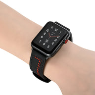 Bracelet Apple Watch en cuir noir avec surpiqûres rouges sur poignet masculin.