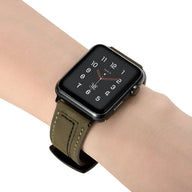 Bracelet Apple Watch en cuir kaki avec coutures apparentes, ajusté sur poignet masculin.