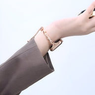 Bracelet Apple Watch en métal torsadé or rosé porté au poignet, style élégant féminin.