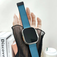 Bracelet Apple Watch en microfibre bleu foncé avec boucle noire, porté sur poignet féminin.