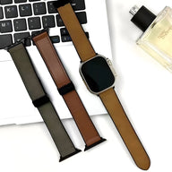 Bracelet Apple Watch en microfibre marron clair avec raccords noirs sur montre carrée argentée, posé sur clavier et à côté.